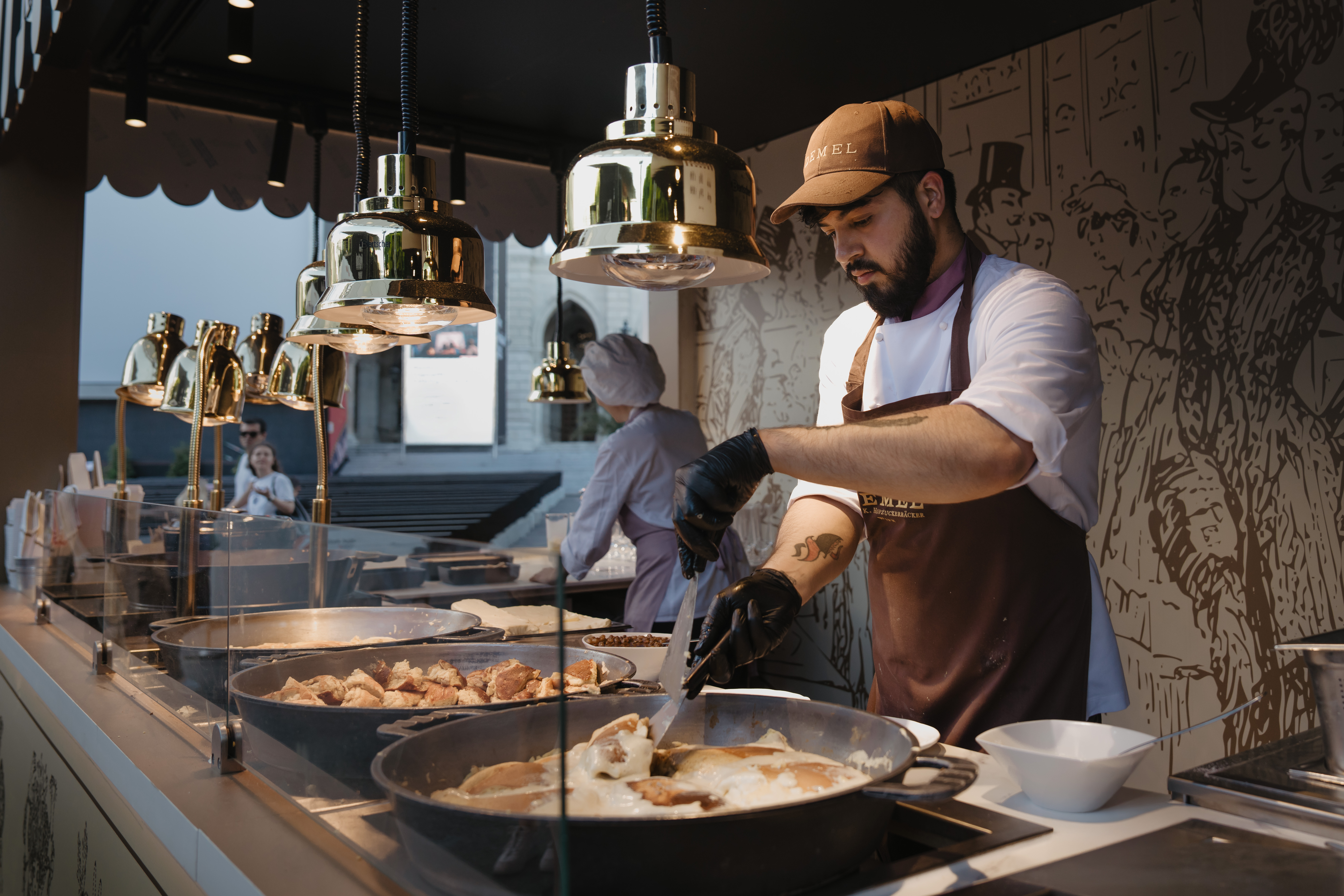 Koch beim zubereiten von Kaiserschmarrn in großen Pfannen