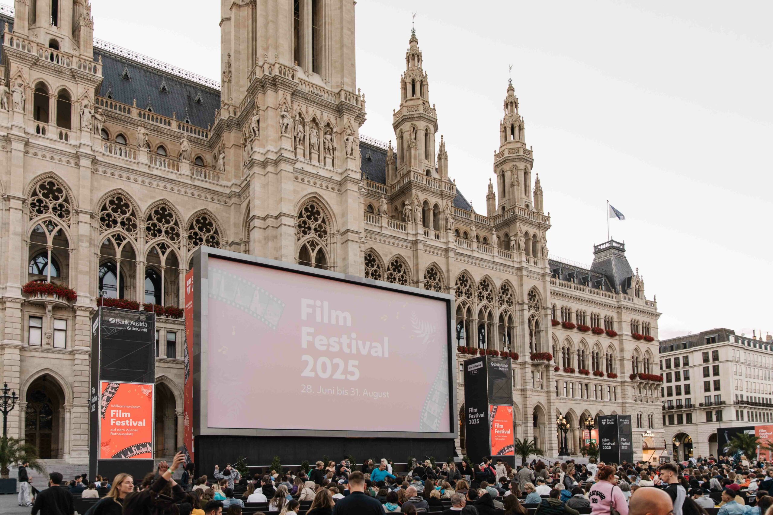 Aufnahme der großen Leinwand vor dem Rathaus bei Tageslicht mit Publikum